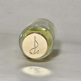 Glass bottle with a gold label featuring a logo on a gray background